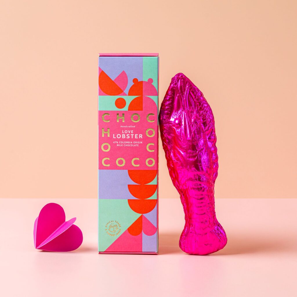 Chococo milk chocolate lobster wrapped in foil leaning against the box it came in