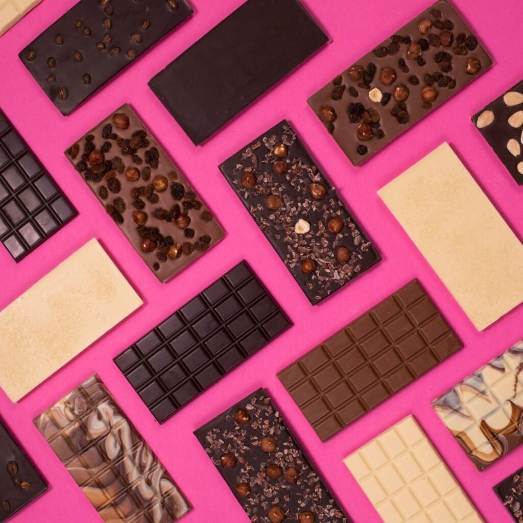 cocoa Loco unwrapped chocolate bars on a pink background