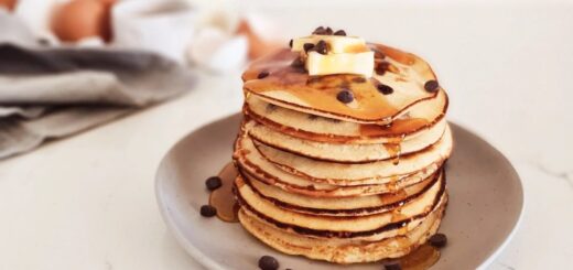 A stack of chocolate chip pancakes on a white plate