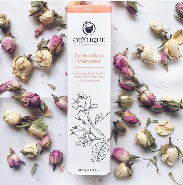 Odylique rose moisturiser box with petals scattered around it