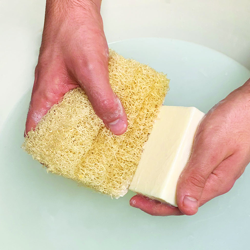 a close up of two hands holding soap and a loofco loofah