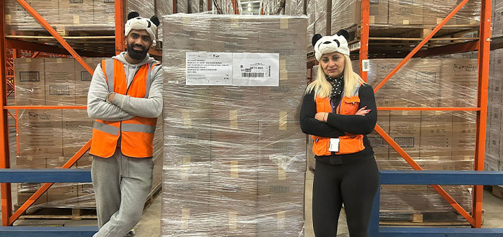 Members of The Cheeky Panda team stood near boxes that will be donated to the foodbank