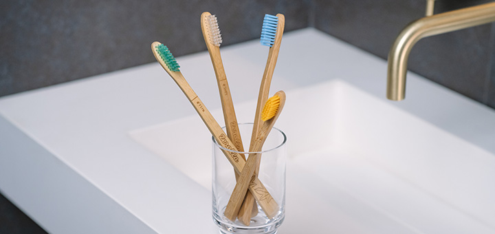 4 zerolla toothbrushes in a glass on a sink