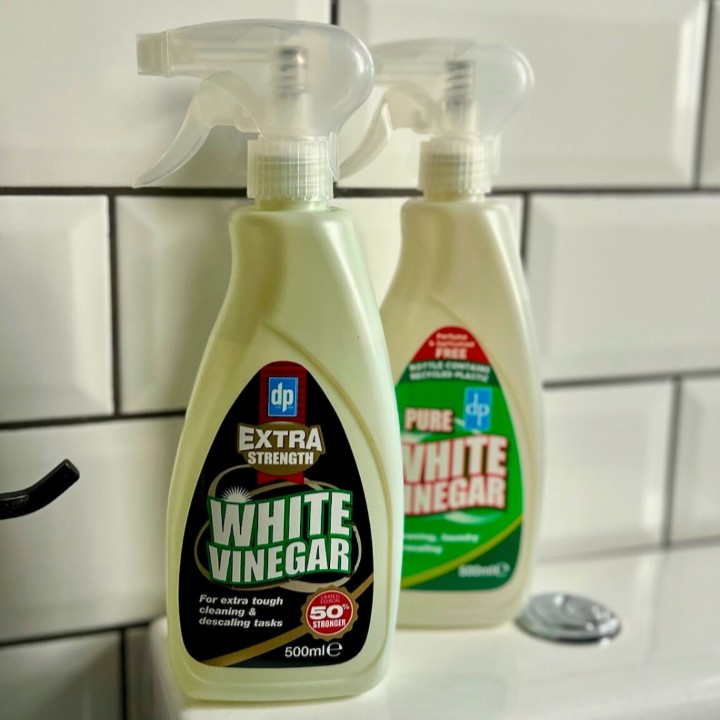 Two bottles of Dri Pak white vinegar displayed in a bathroom