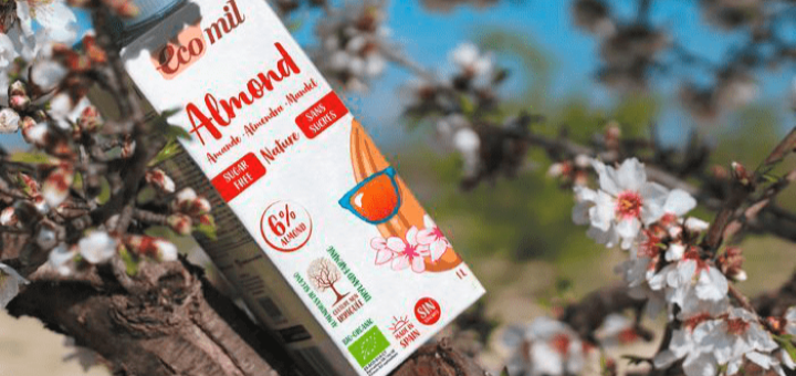 A carton of EcoMil Almond drink resting on a tree branch