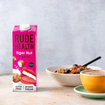 A bottle of Rude Health tiger nut milk alongside some bircher muesli and a cup of coffee