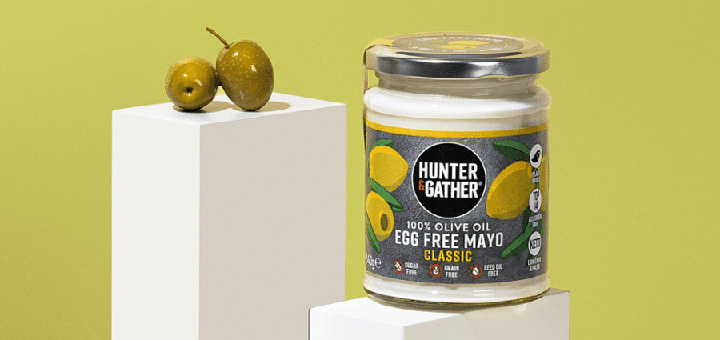 A jar of Hunter & Gather egg free mayo on a white plinth against a green background