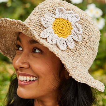 A close up of a woman wearing a Pachamama sun hat