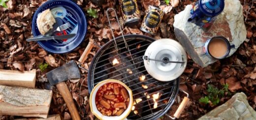 Suma baked beans and vegan sausages being cooked over a campfire