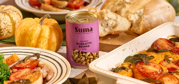 Suma Organic tin of barlotti beans on a table of cooked items